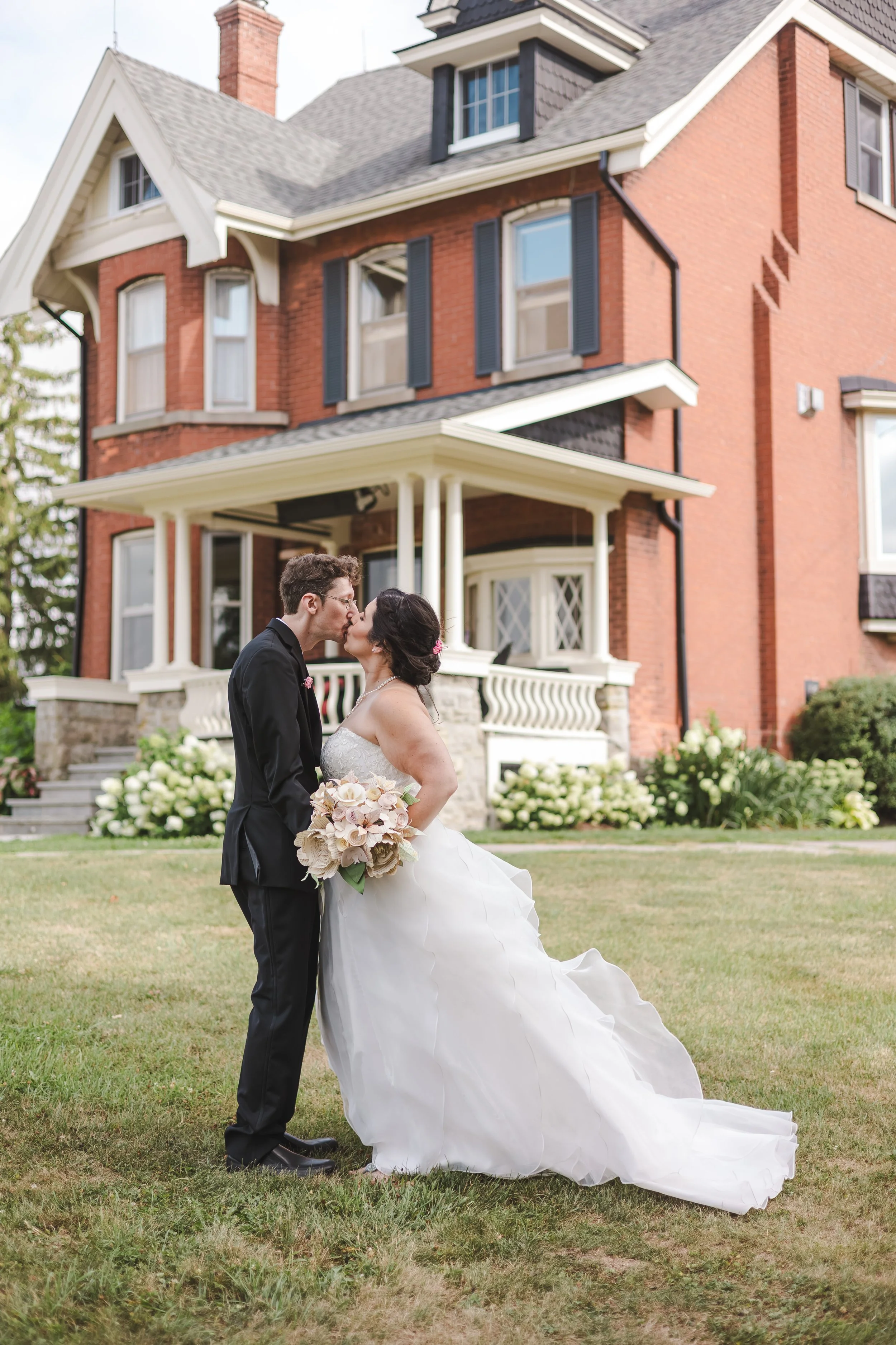 couple-wedding-photo-standing-in-front-of-house-fedora-media.jpg