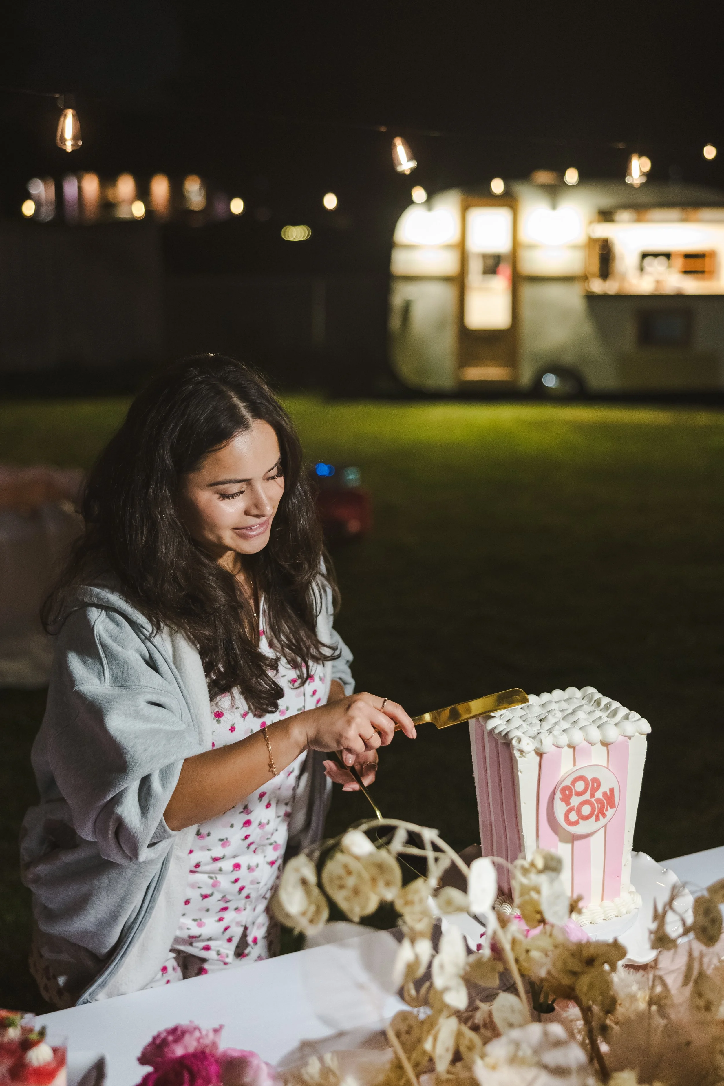 woman-cutting-popcorn-bucket-cake-movie-night-fedora-media.jpg