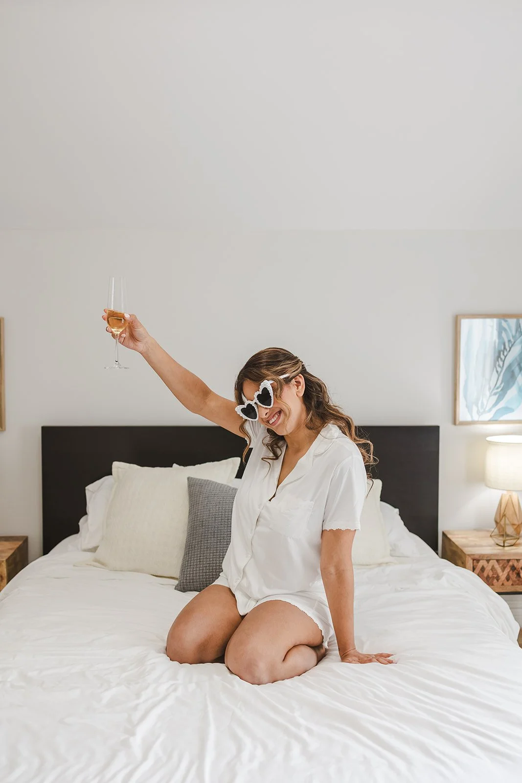 Bride in heart sungalsses on bed with champagne  River's Edge  Arlington Hotel  Paris, ON  Fedora Media.jpg
