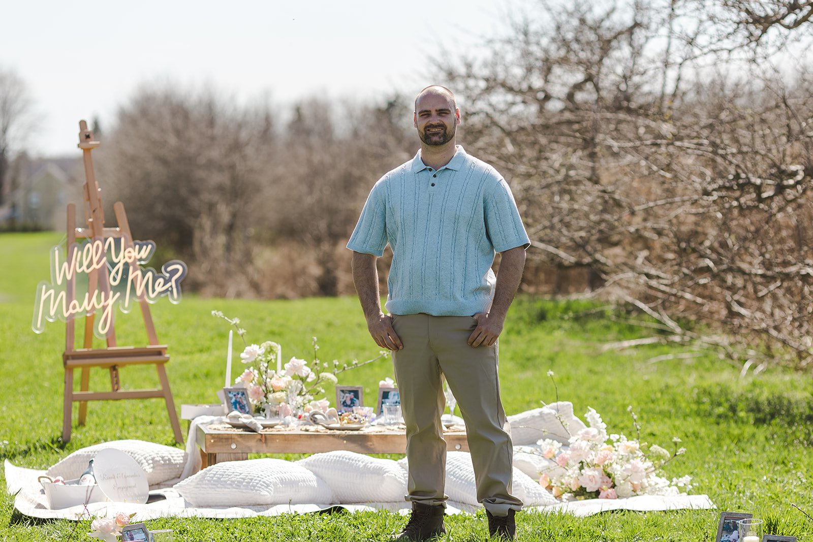 Man in blue shirt smiling standing in front of picnic set up  Orchard Propsal  Fedora Media.jpg