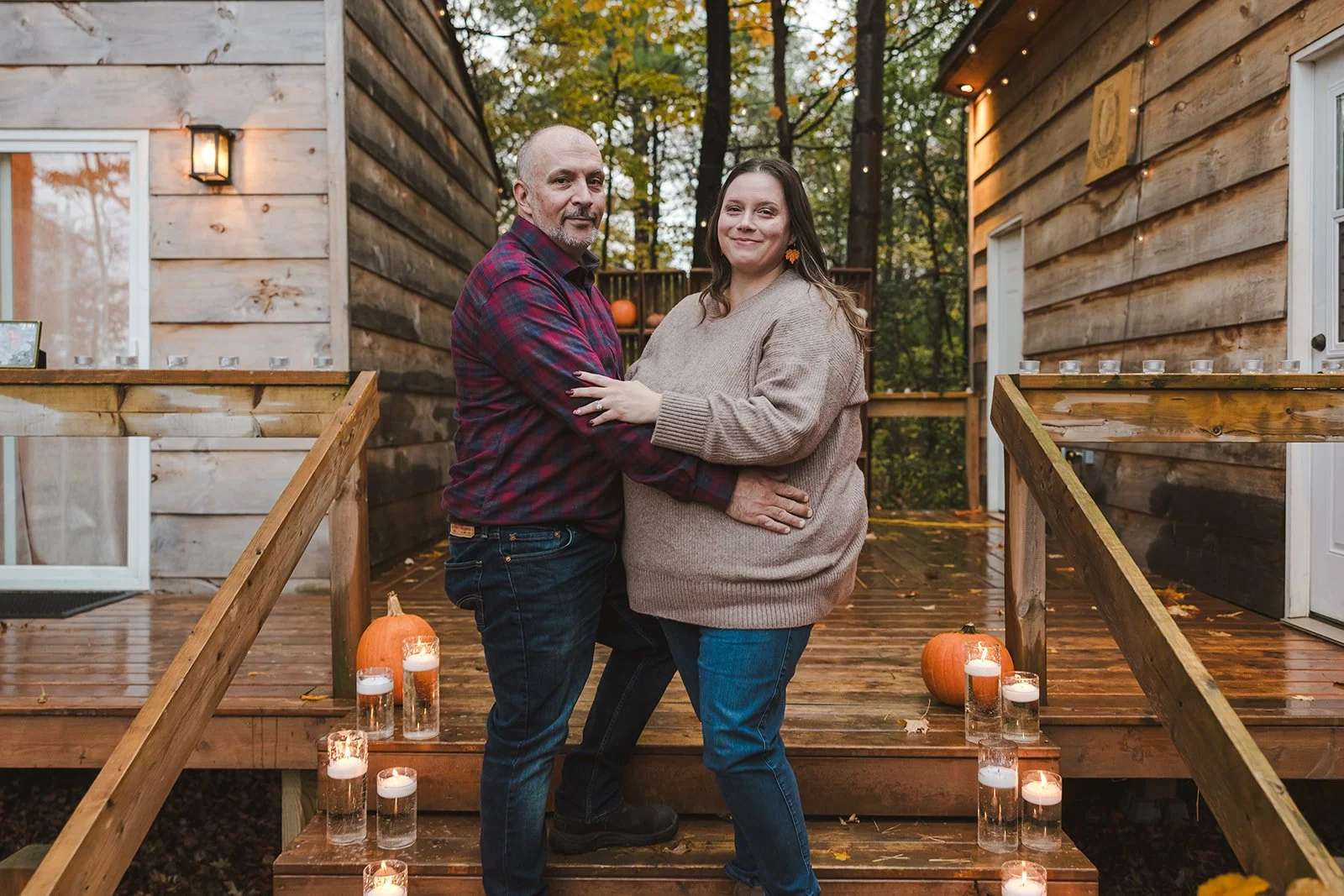 Couple smiling and embracing standing on stairs  Cabin Propsal  Fedora Media.jpg
