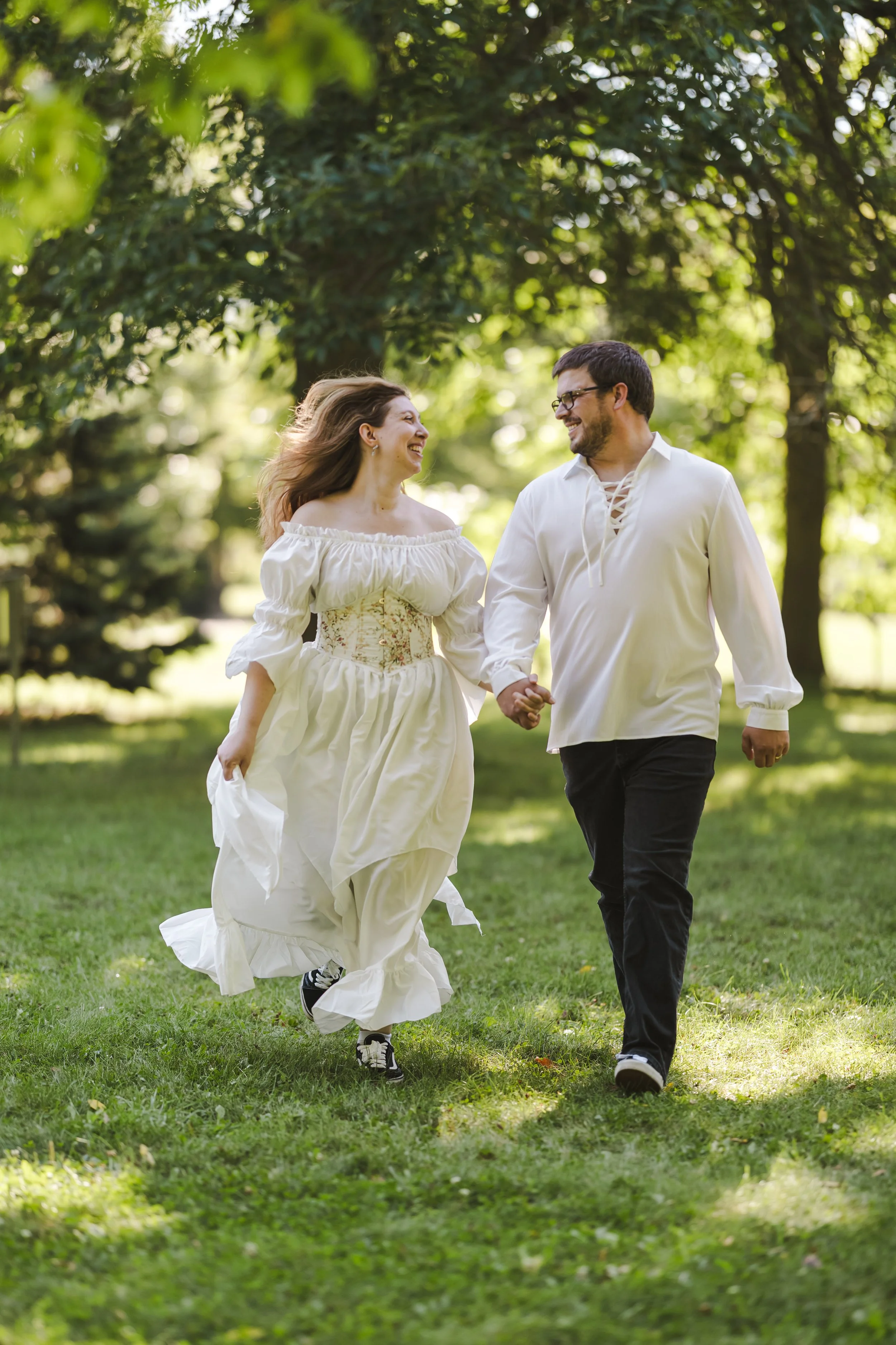 woman-with-flowy-dress-holding-hands-with-man-in-white-top-fedora-media.jpg