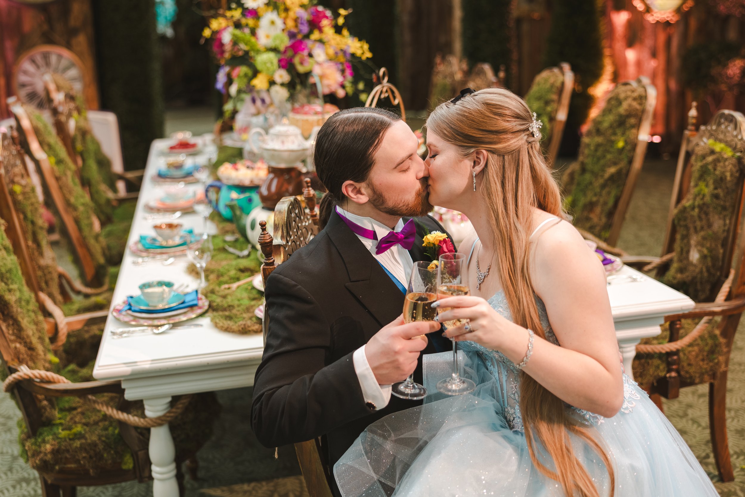 bride-and-groom-holding-drinks-while-kissing-alice-in-bloomland-fedora-media.jpg