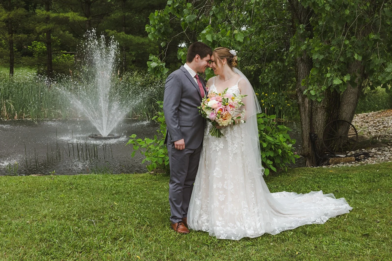 Bride and groom in front of pond fountain  Boho Wedding  Fedora Media.jpg