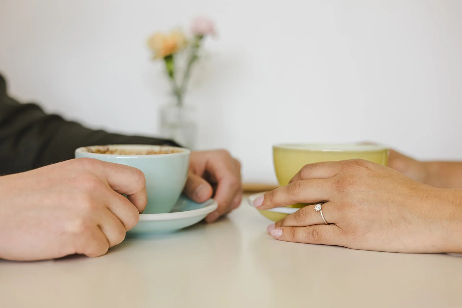 Couple holding coffee cups with engagement rign  Ontario Engagement  Fedora Media.jpg