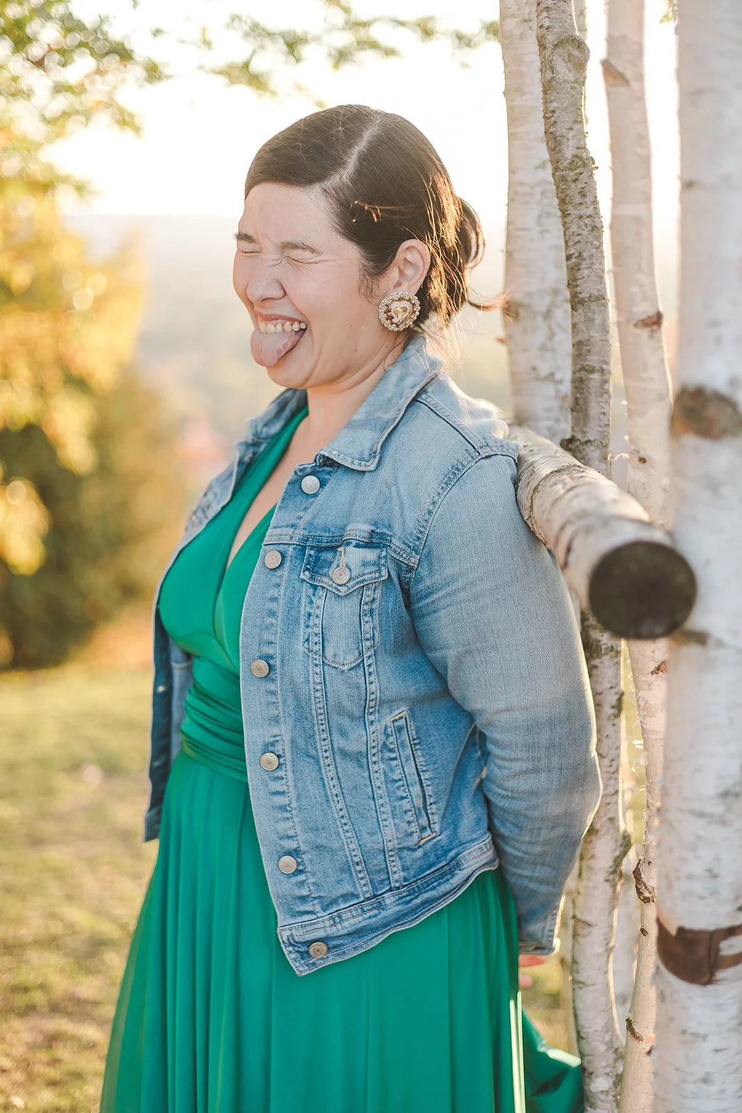 Woman sticking out toungue in green dress and jean jacket  Ontario Engagement  Fedora Media.jpg