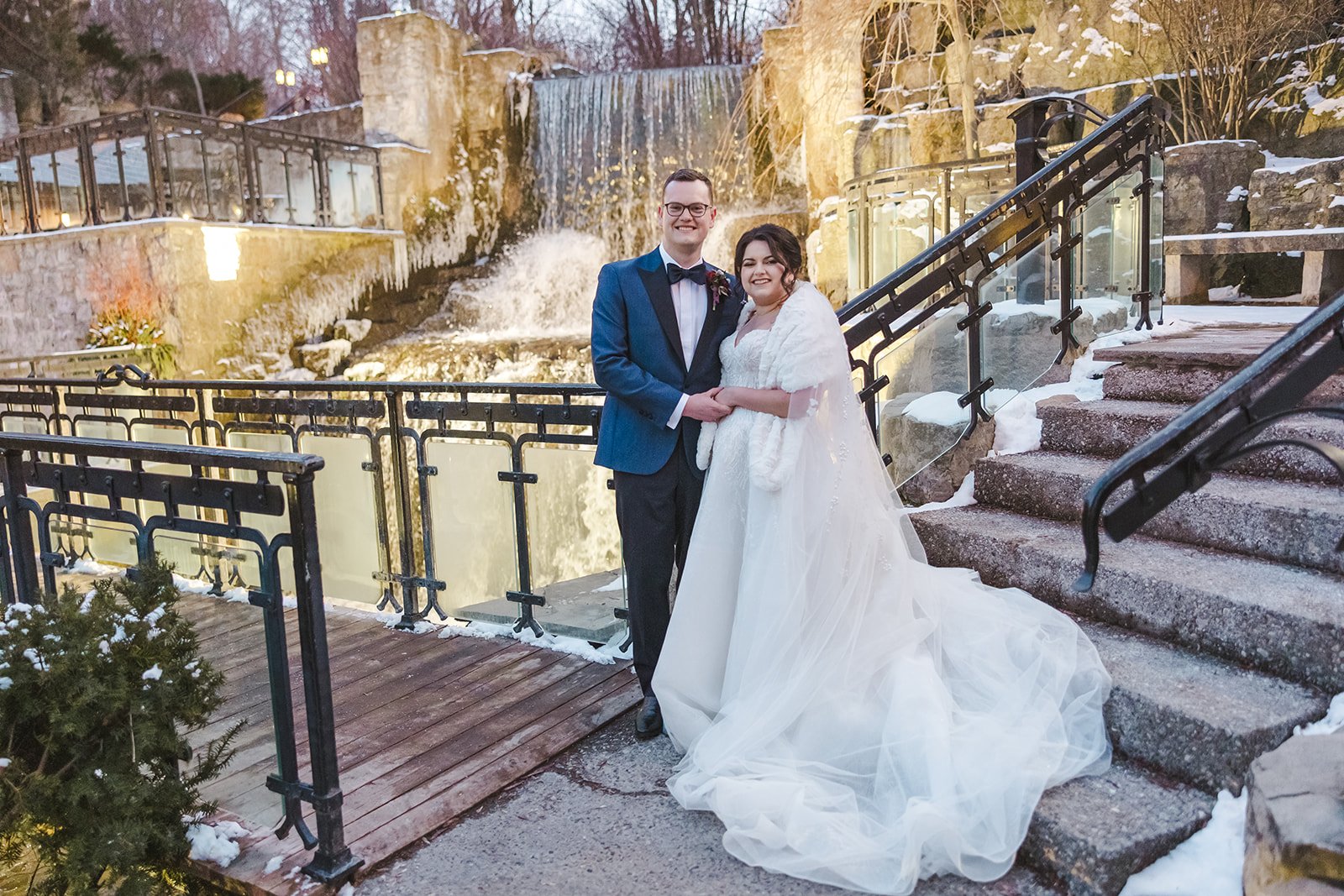 Bride and groom embrace in front of waterfall  Ancaster,  ON  Ancaster Mill  Fedora Media.jpg