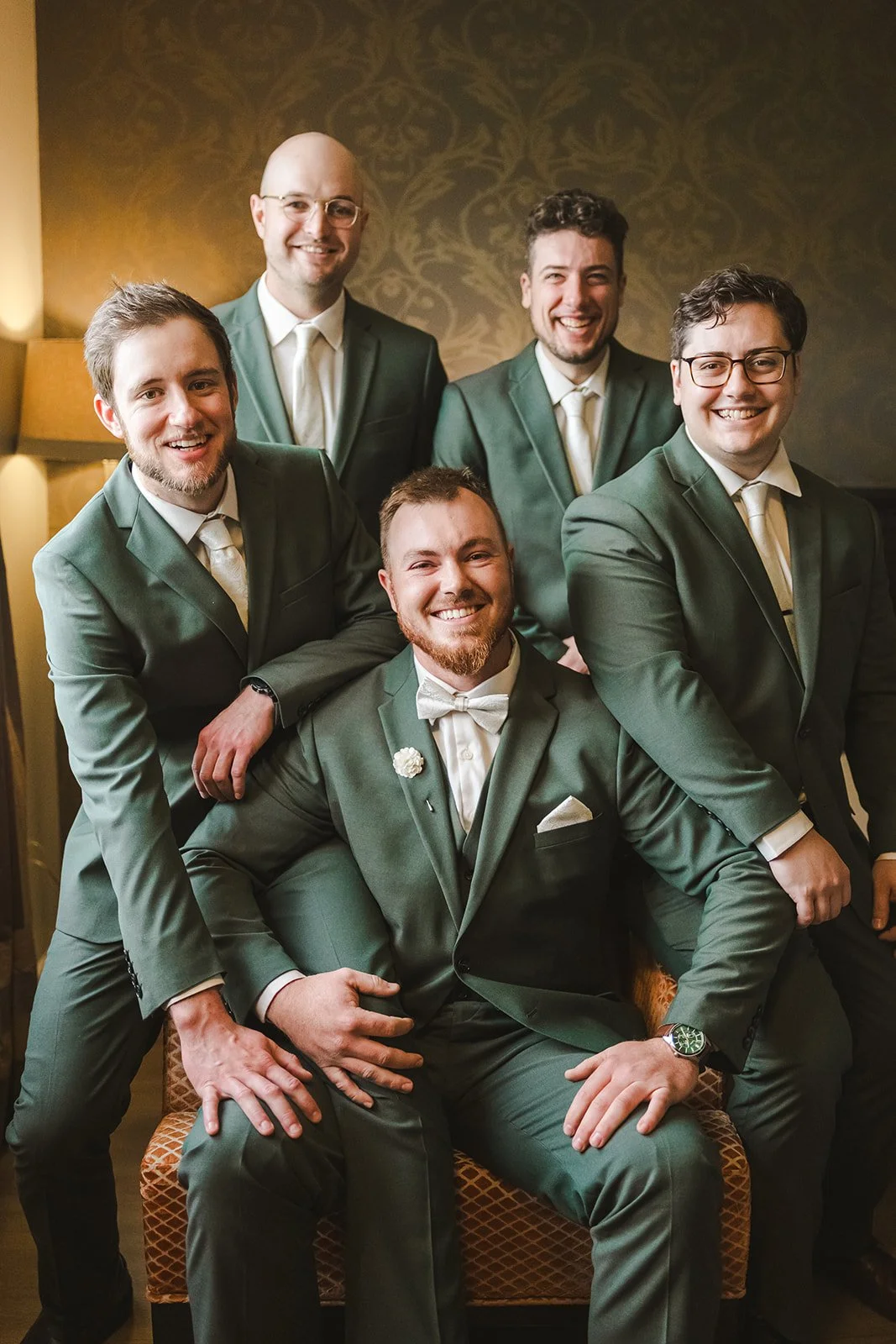 Groom sitting with groomsmen in green suits  fall wedding  Fedora Media.jpg