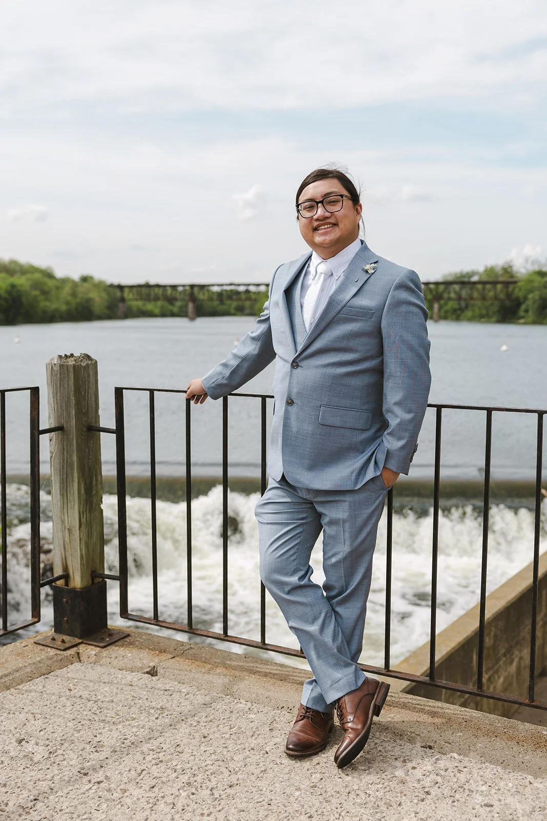 Groom in grey suit standing along river  Cambridge,  ON  Cambridge Mill  Fedora Media.jpg