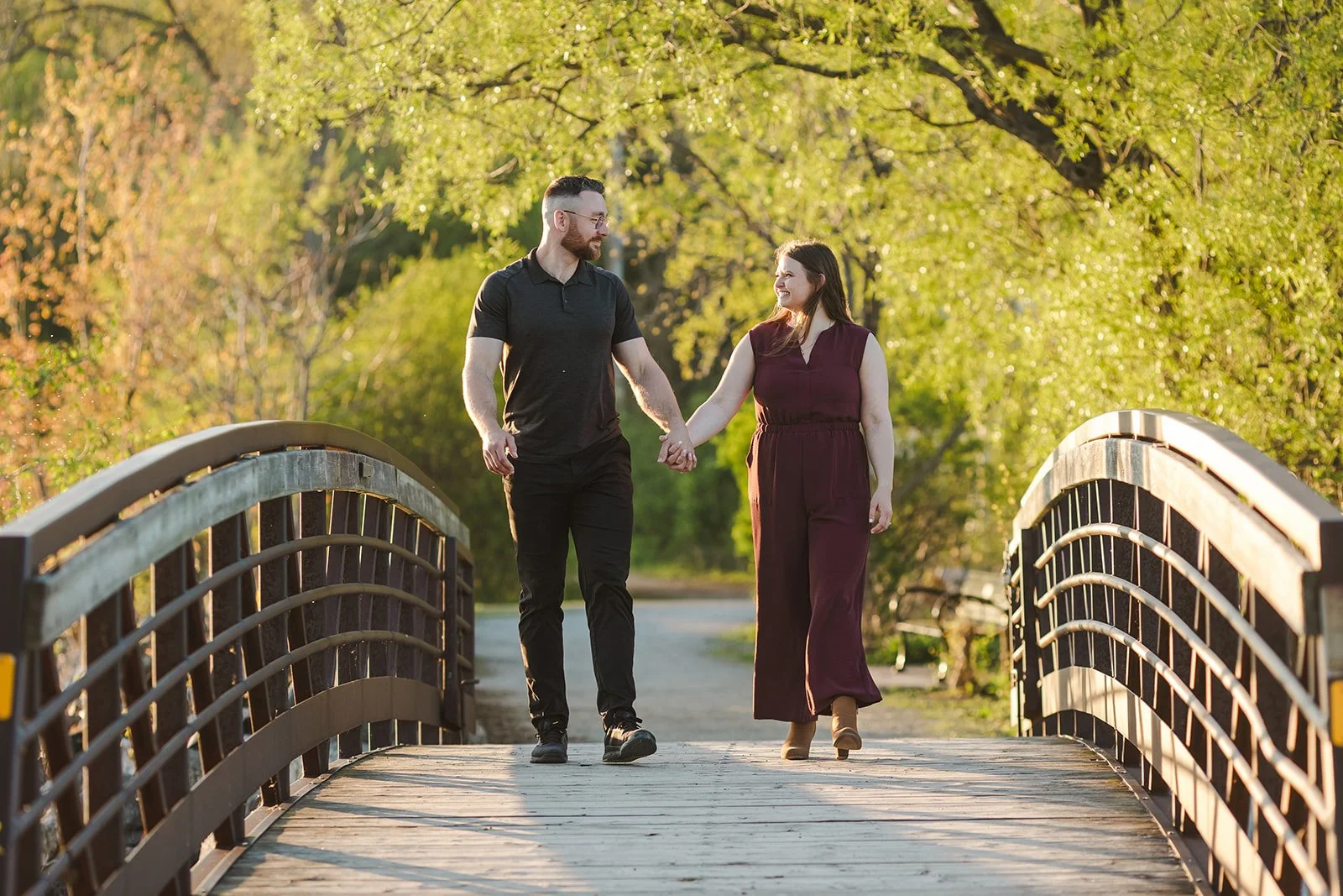 Couple walking holding hands on bridge  Ontario Engagement  Fedora Media.jpg