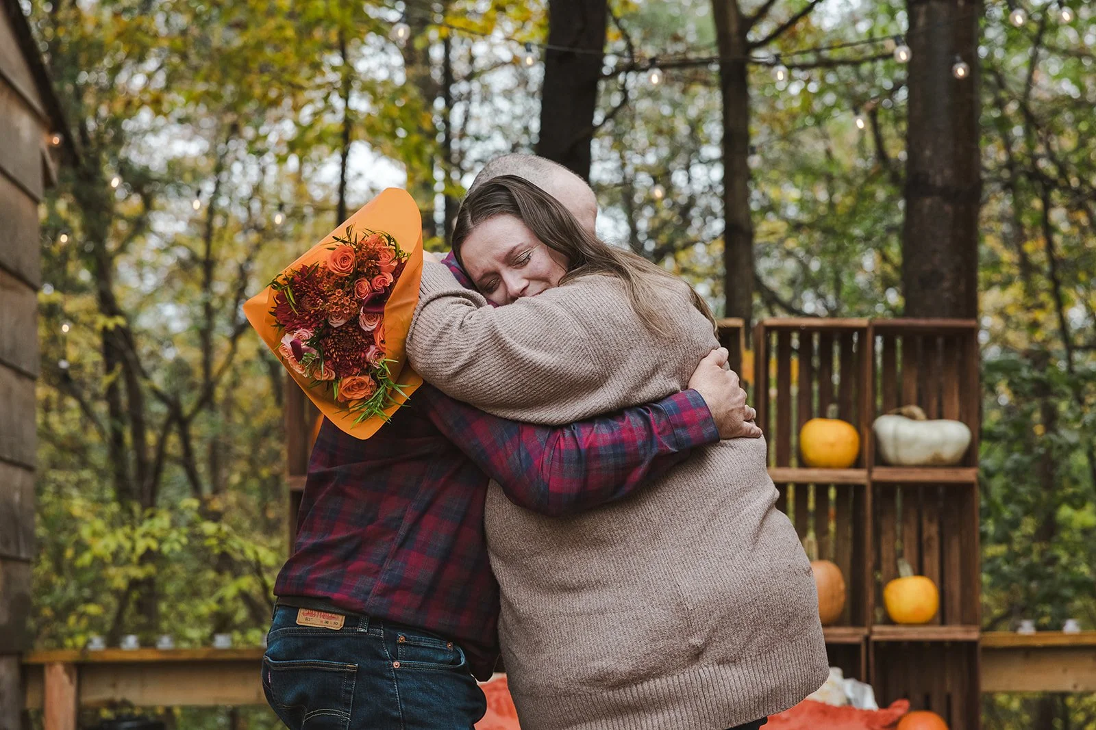 Couple embracing with flower bouquet  Cabin Propsal  Fedora Media.jpg
