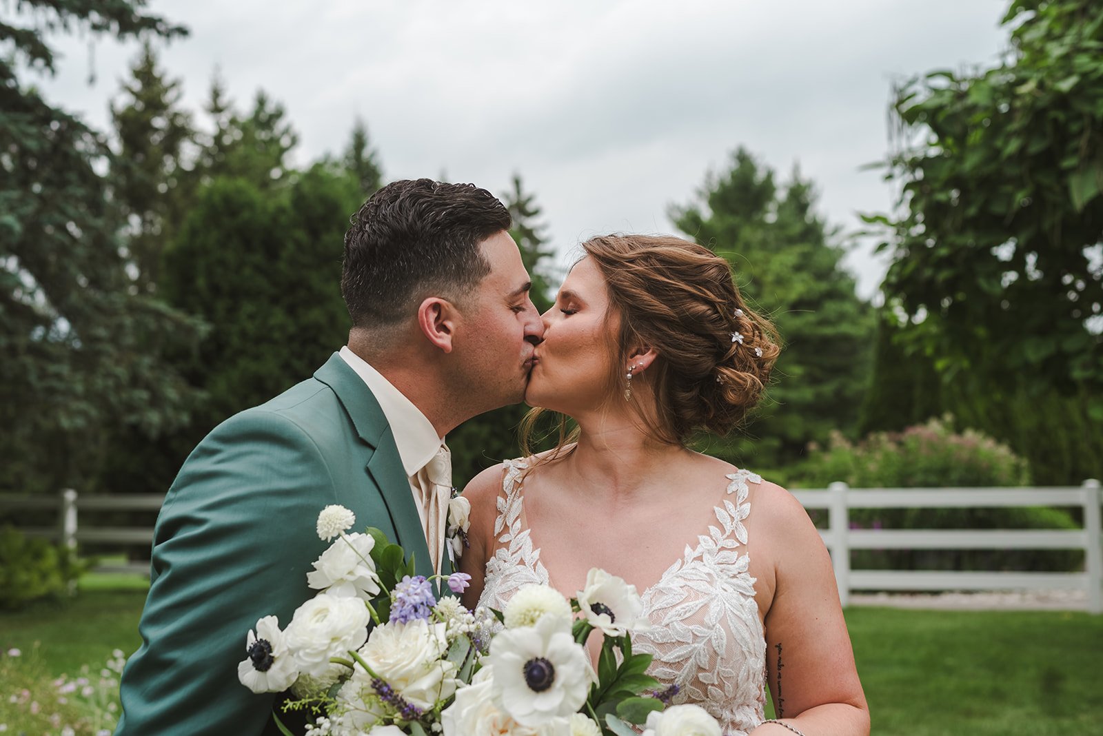 Bride and groom kiss in field  Springfield Golf & Country Club  Fedora Media.jpg