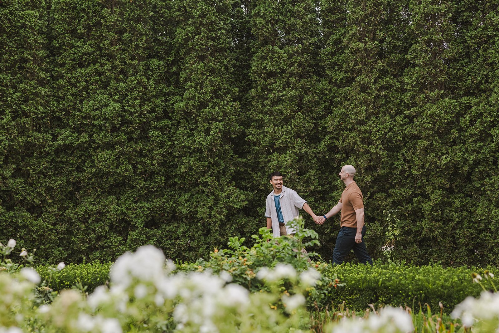 Couple walking in garden holding hands  Ontario Engagement  Fedora Media.jpg