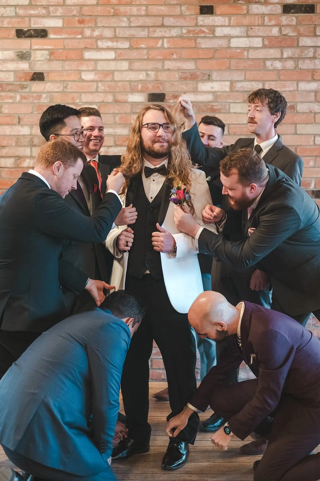 Groomsmen helping to fix grooms suit  Rivers Edge  Paris, ON  Fedora Media.jpg