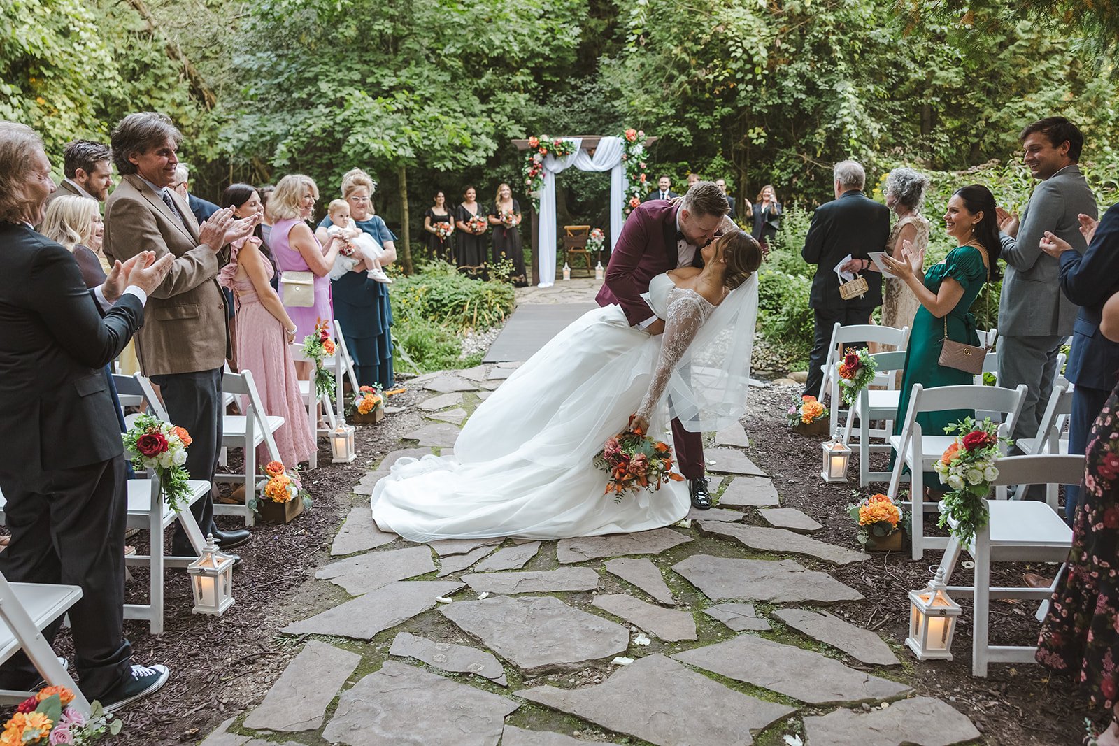 Bride and groom dip kiss in aisle guests clapping  Erin Estates  Fedora Media.jpg