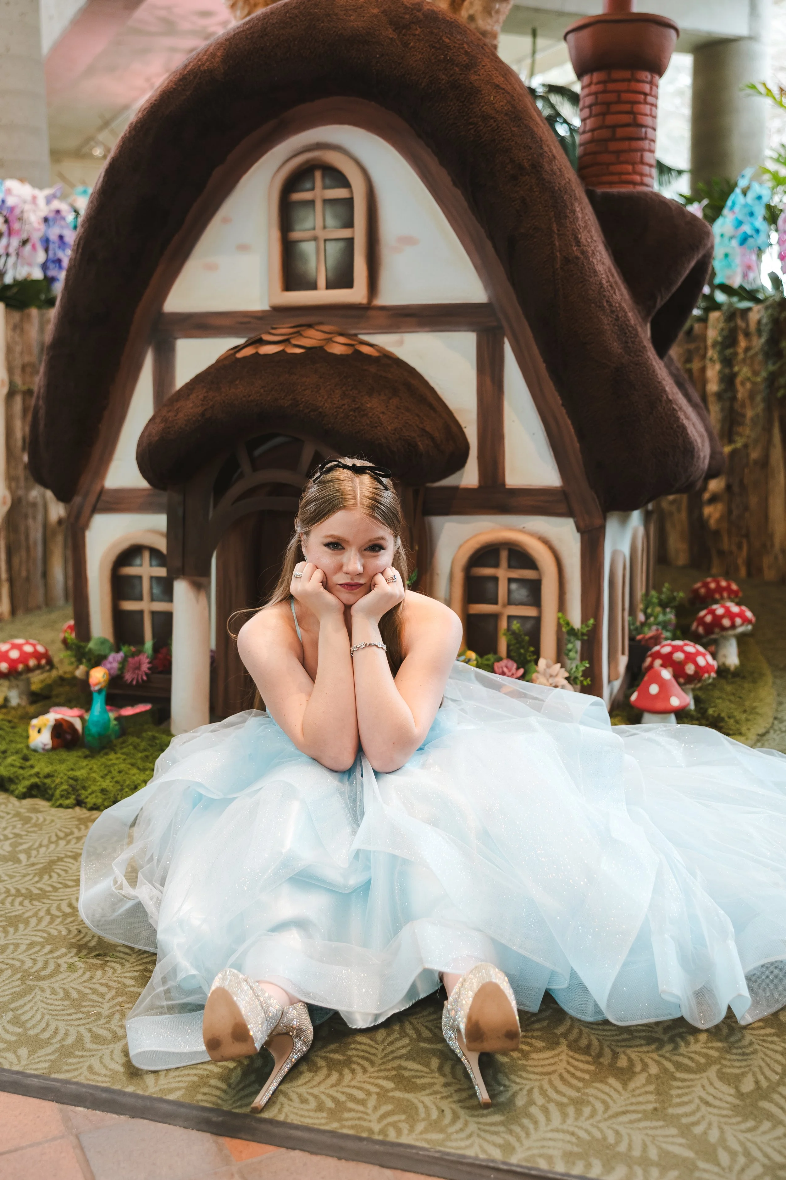 bride-in-blue-dress-sits-in-front-of-house-alice-in-bloomland-fedora-media.jpg