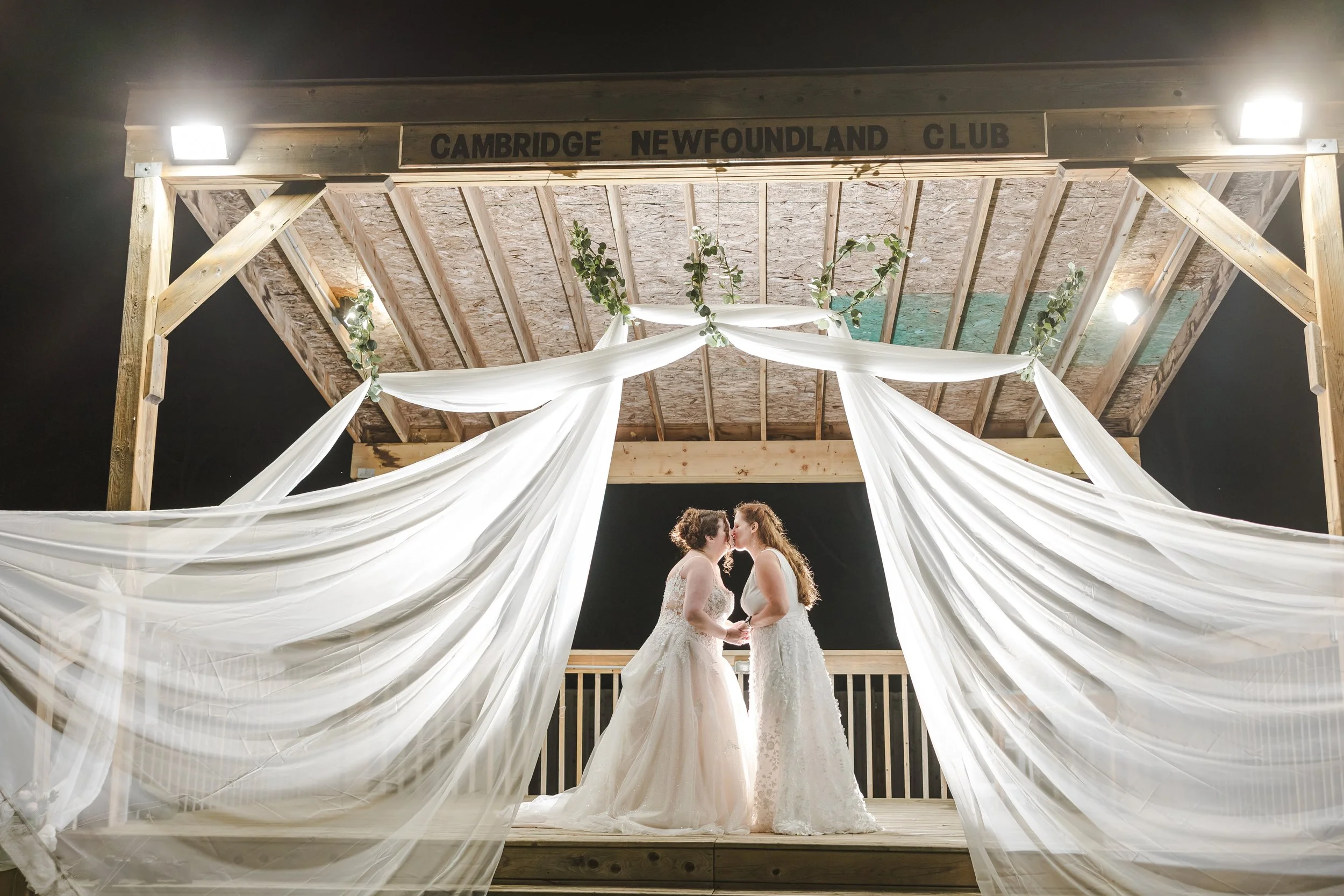 brides-on-poarch-kissing-with-veils--newfoundlandclub-cambridge-ontario.jpg