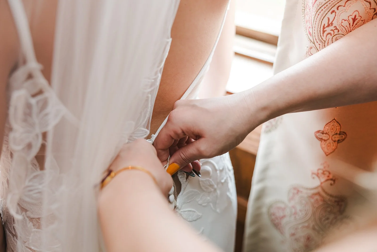Bride being helped into dress  Erin Estates  Fedora Media.jpg