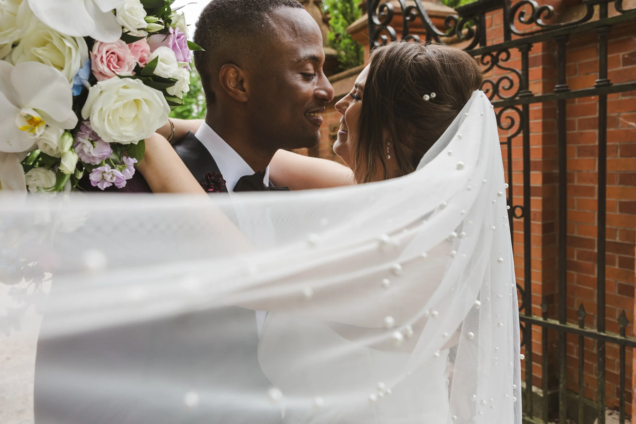 couple-embrace-with-veil-covering-fedora-media.jpg
