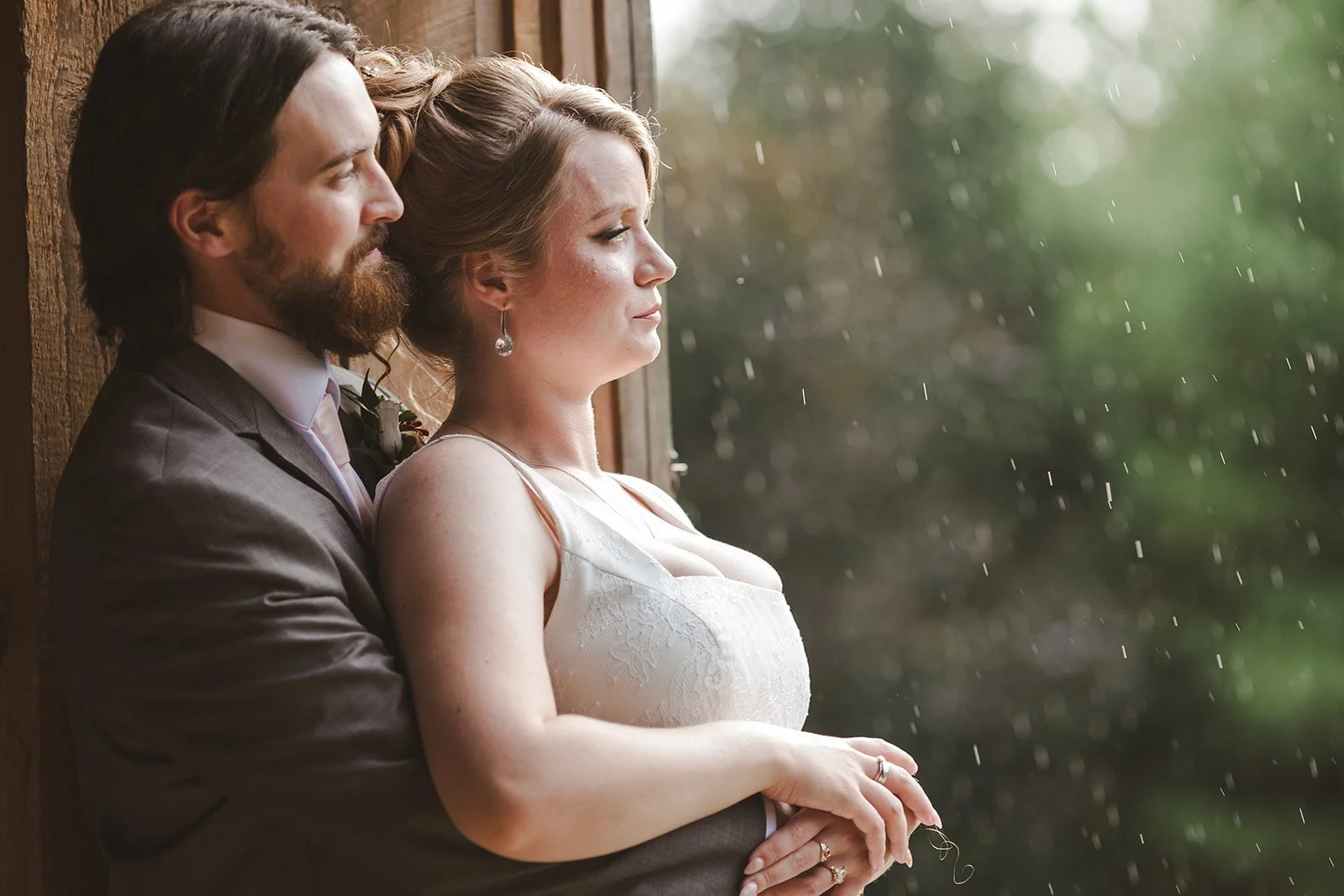 bridge and groom watch the rain on their wedding day.jpg