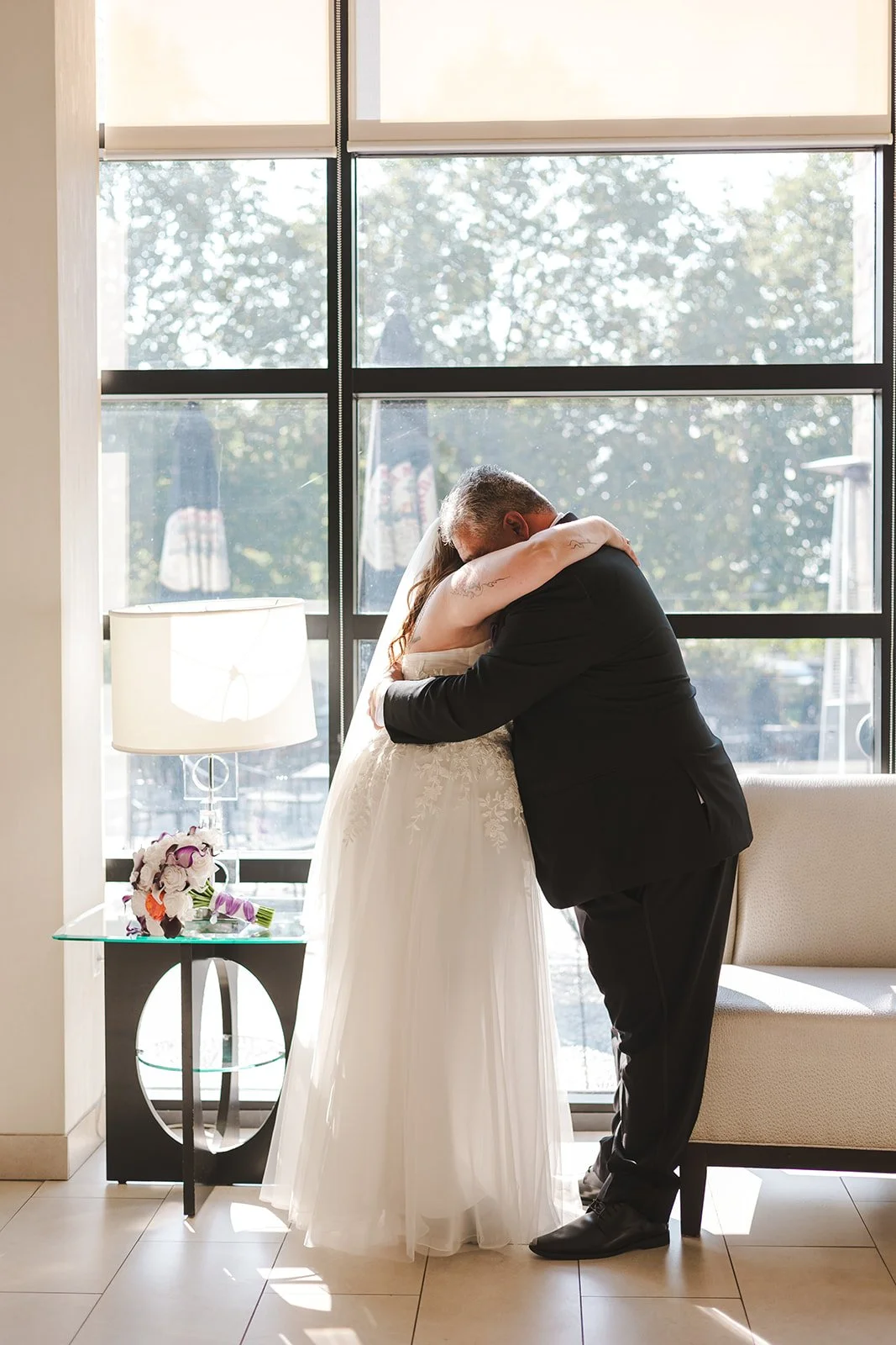 Bride and groom share an intimate hug in fron of window Hamilton, ON  Carmen's Hotel  Fedora Media.jpg