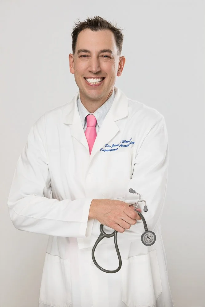 male doctor smiling in lab coat in white photography studio