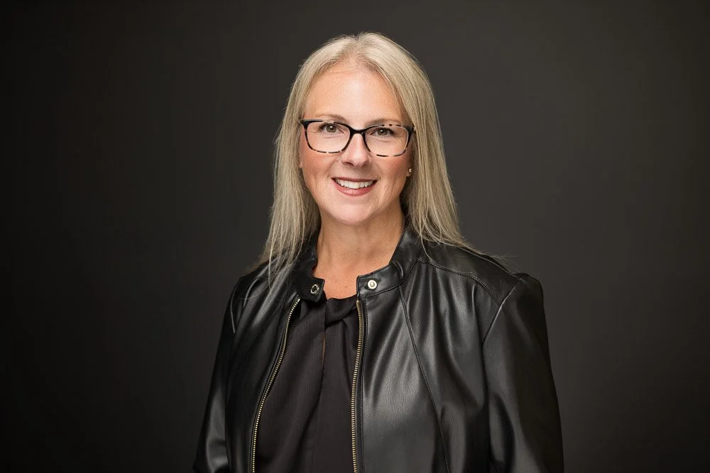 professional headshot of a blonde woman wearing black leather jacket