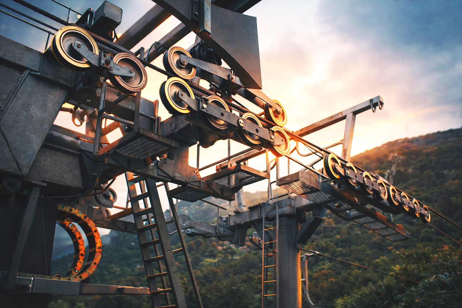Estructura de un telesilla de ski o gondola en un paisaje montañoso al atardecer.