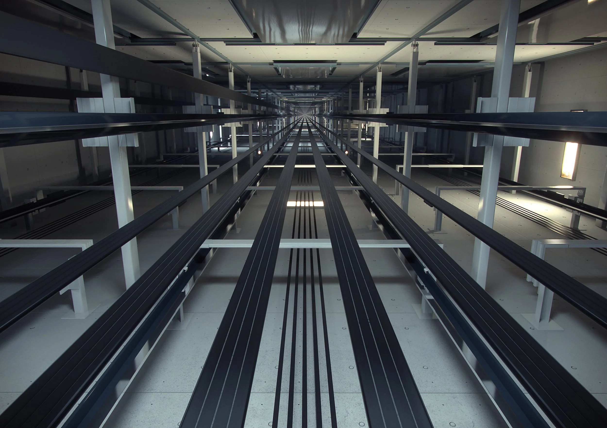 Vista interior de un edificio de doble nivel con columnas blancas, donde hay múltiples pasarelas negras y cables running en línea recta hacia el fondo, con paredes de color gris claro y ventanas altas que dejan entrar luz