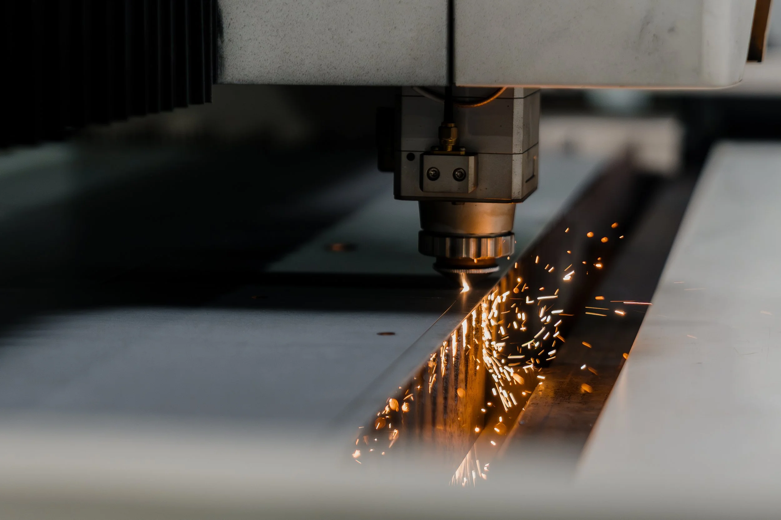 Una máquina cortando metal con chispas brillantes y destellos de luz.