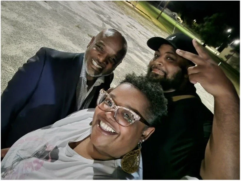 3 adults similing for the camera