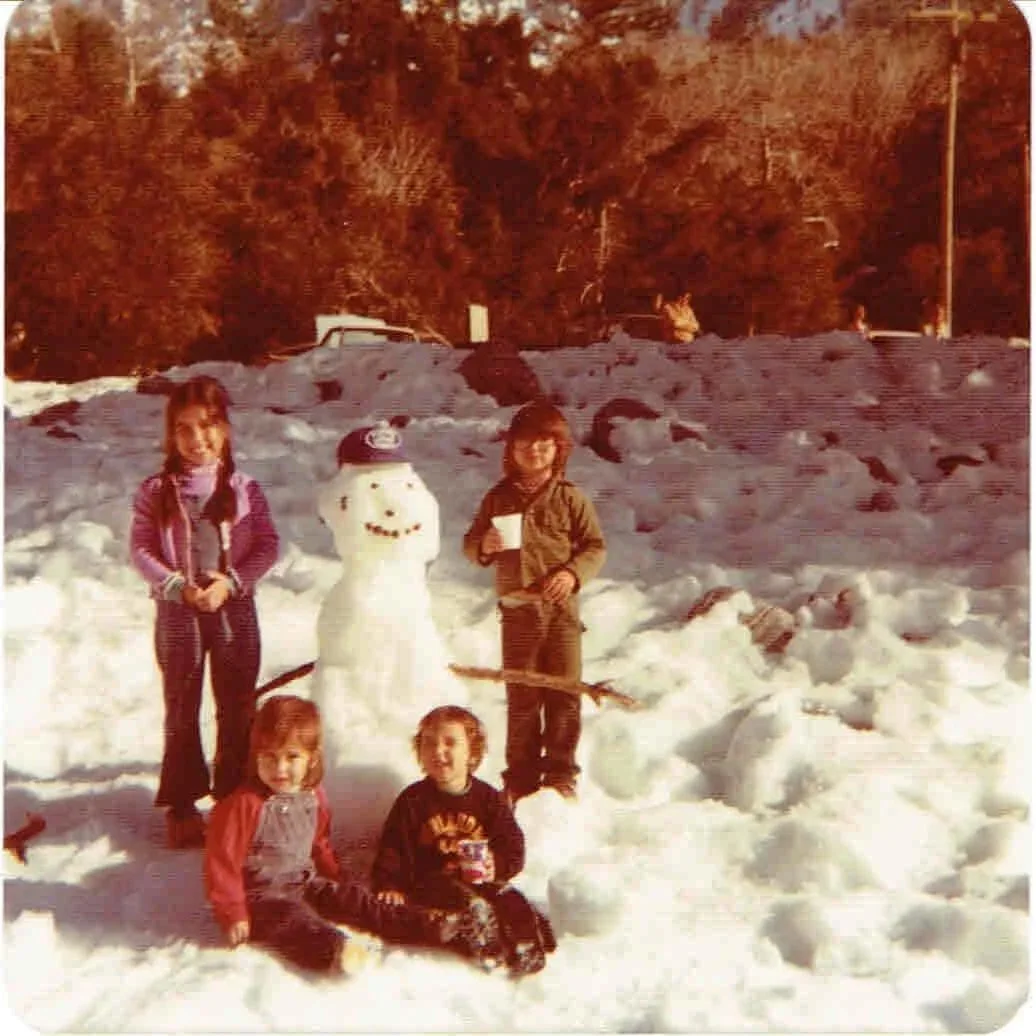 four children building a snowman 1970s