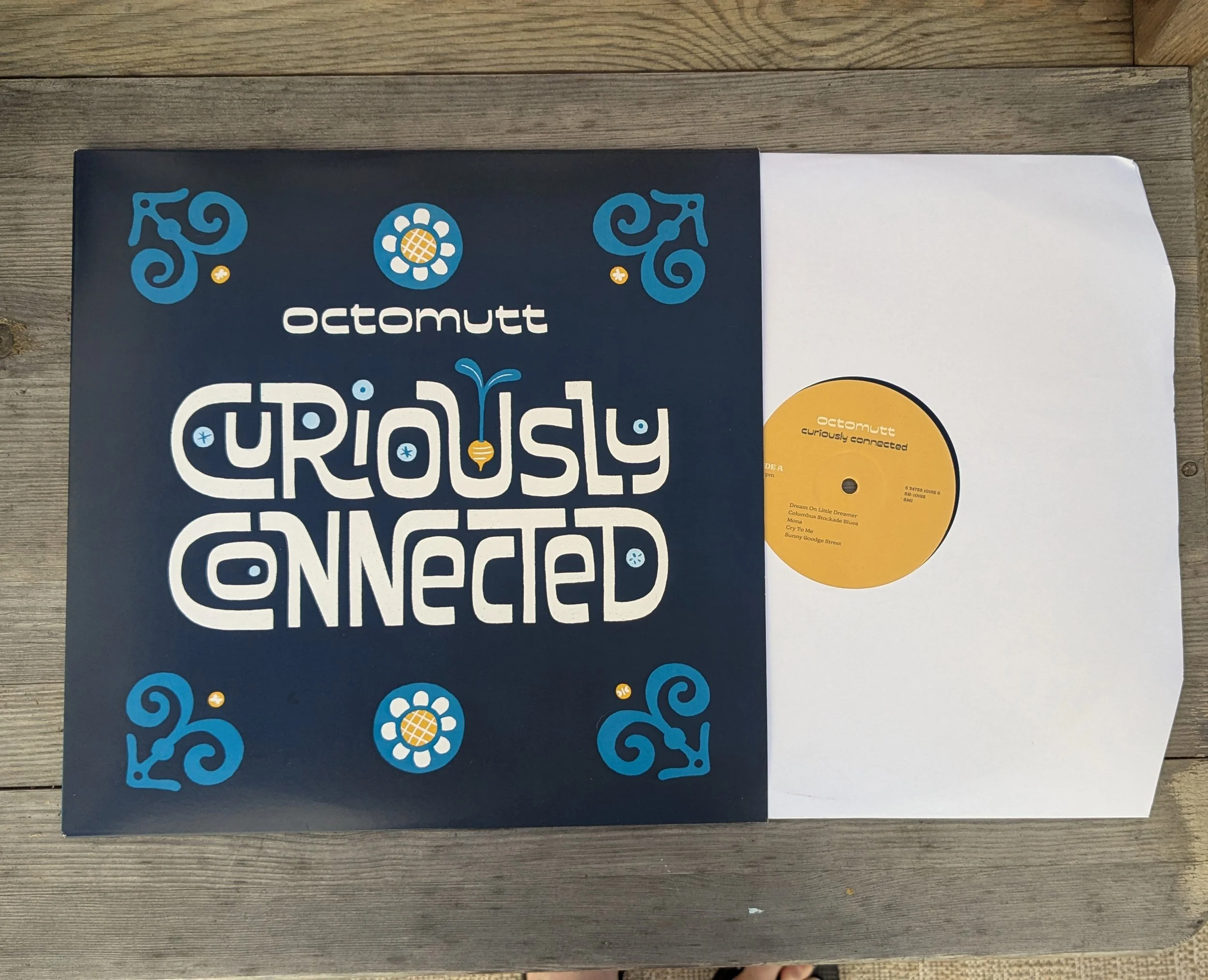 Record sleeve with octomutt album titled 'Curiously Connected' and a yellow vinyl record inside.