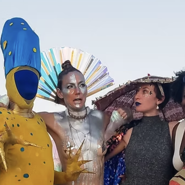 Three people dressed in colorful costumes