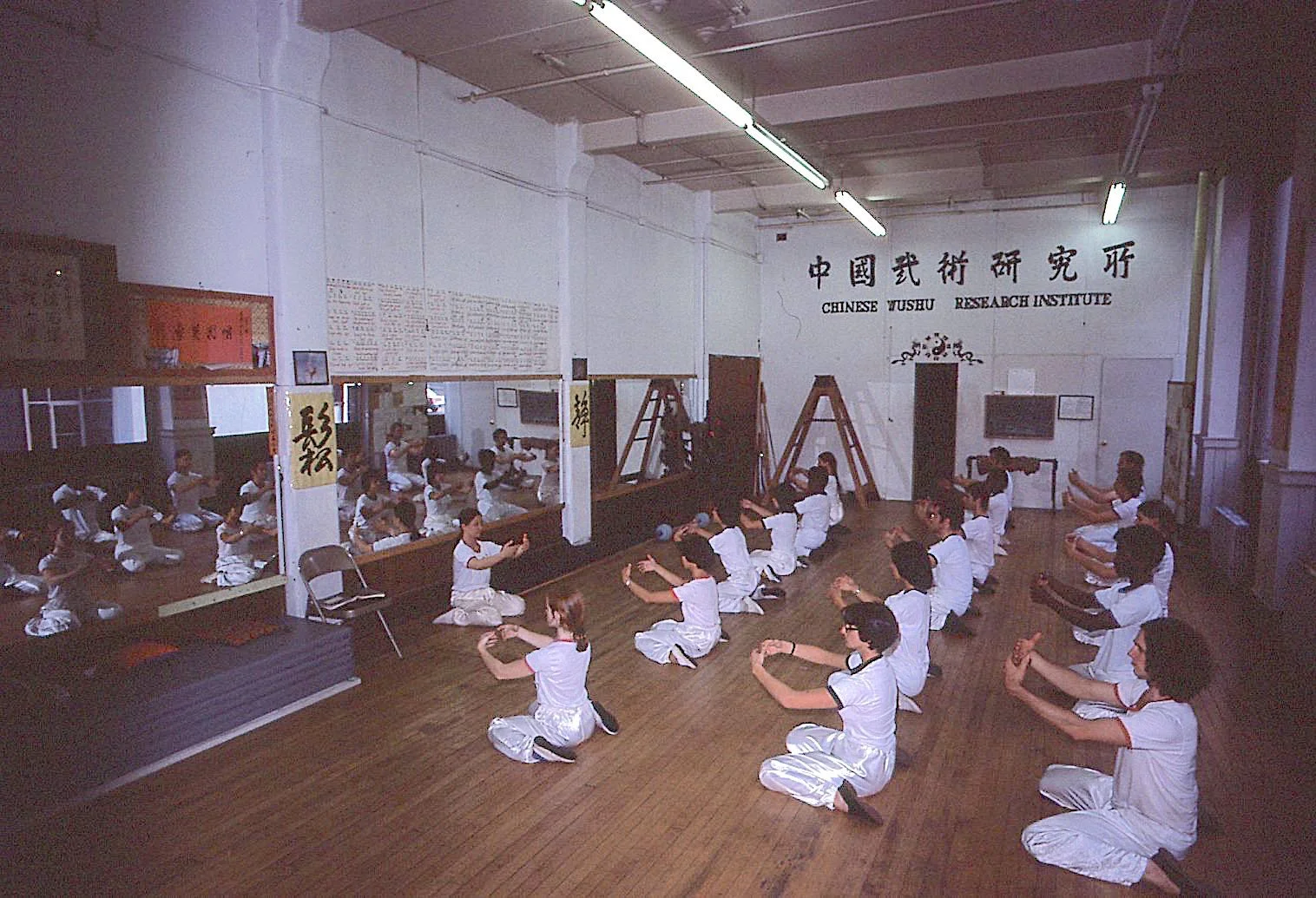 Bow Sim Mark leading young students in a group class practicing Tai Chi meditation exercises at the Chinese Wushu Research Institute in Boston.
