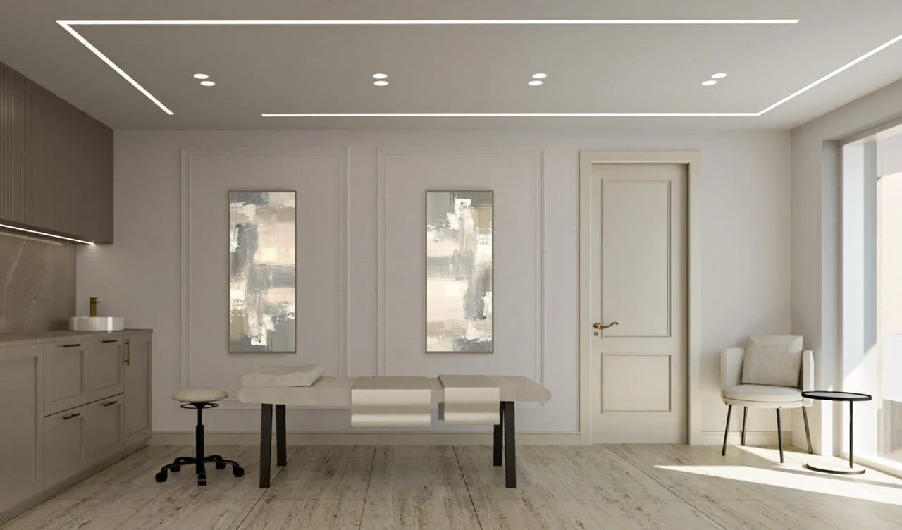 Modernus, minimalistinis procedūrų kabinetas su baltu masažo stalu, spintele ir jaukiu apšvietimu.