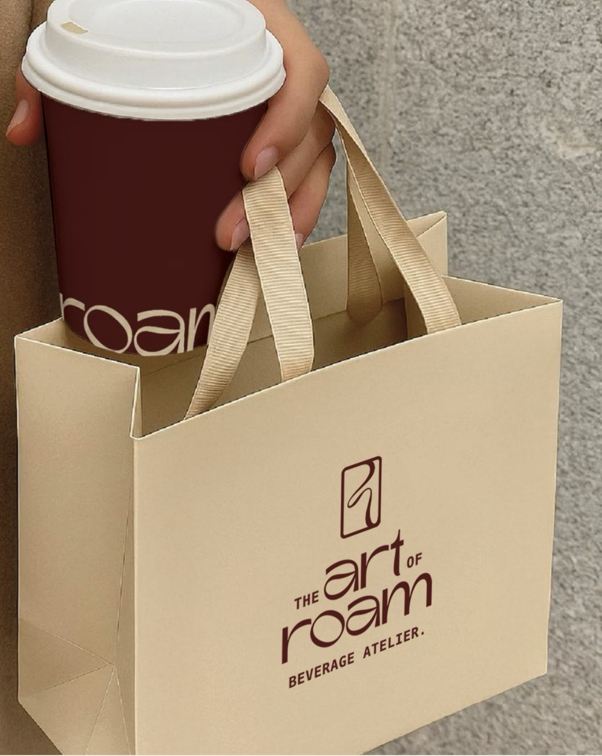 Branded coffee cup and shopping bag from The Art of Roam