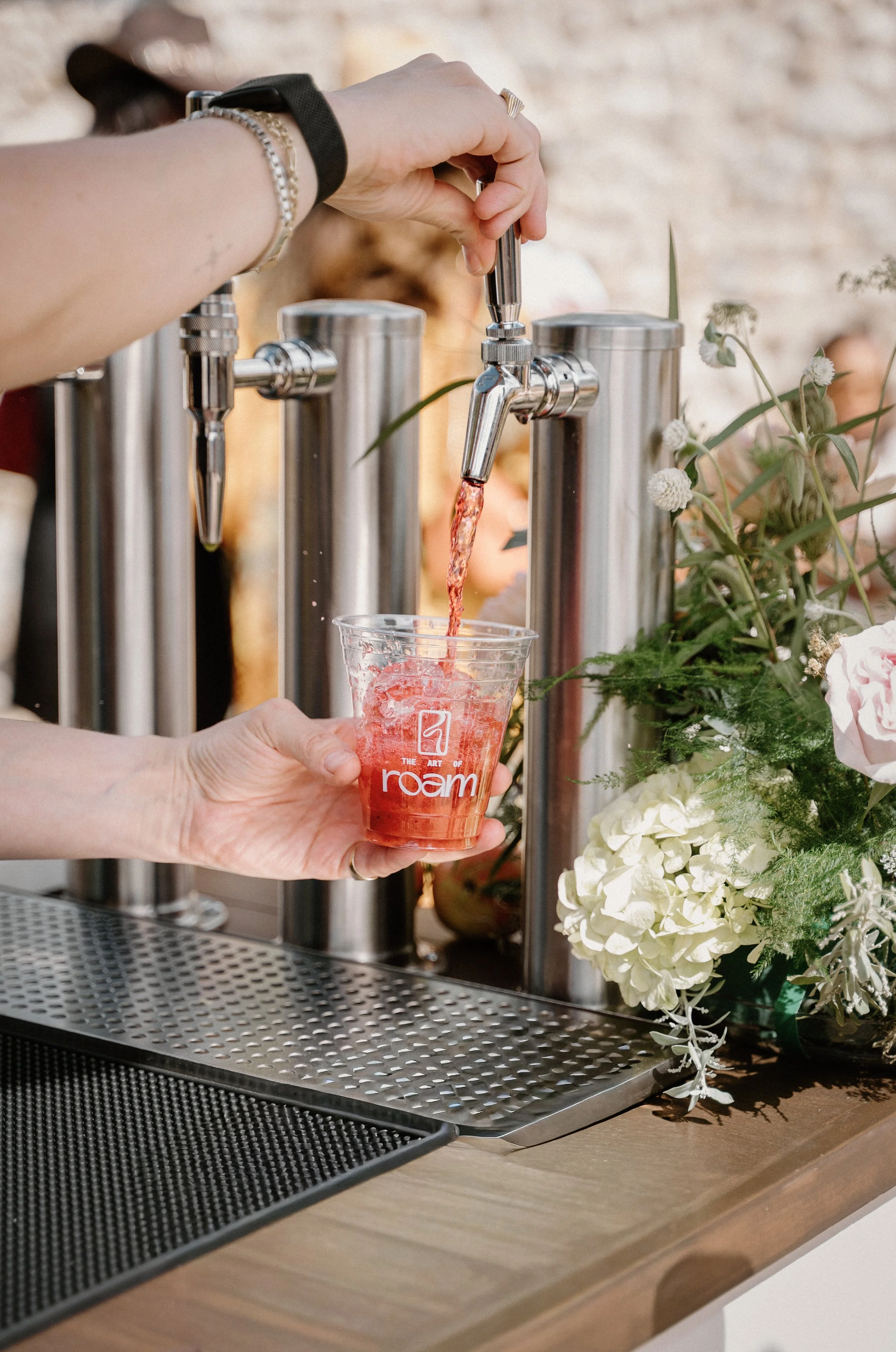 Barista preparing a strawberry specialty beverage at The Art of Roam mobile drink cart.