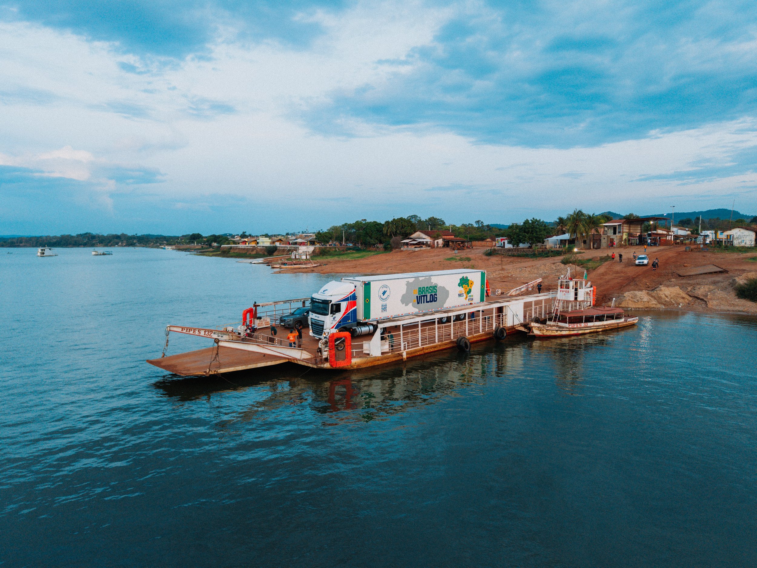 Frame de filme institucional: caminhão em transporte fluvial