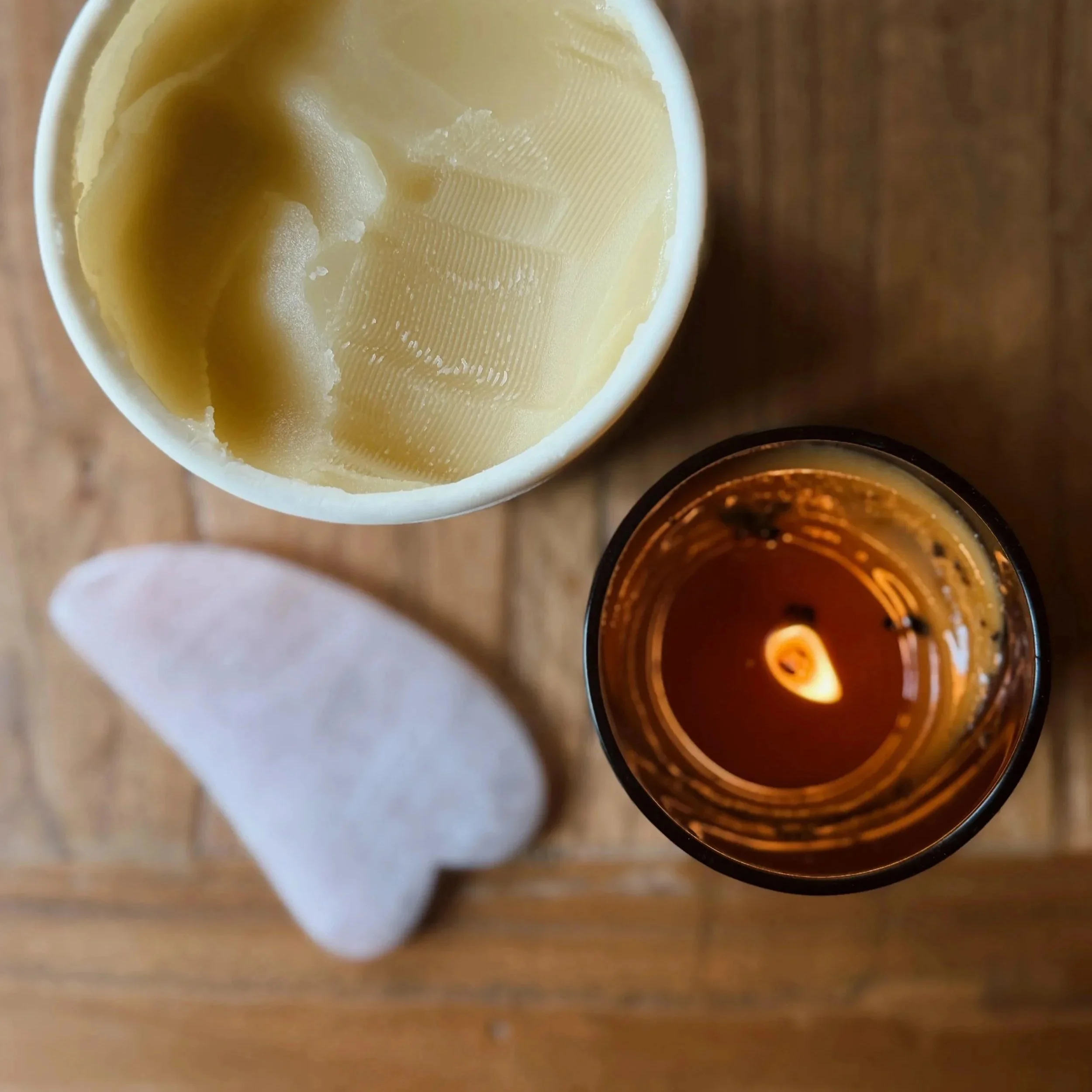 All natural ingredient massage balm, a candle and a rose quartz gua sha tool ready to complete a massage and body work treatment in greater Geelong region.