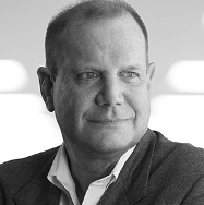 A black and white portrait of a man in a suit, looking slightly to the side.