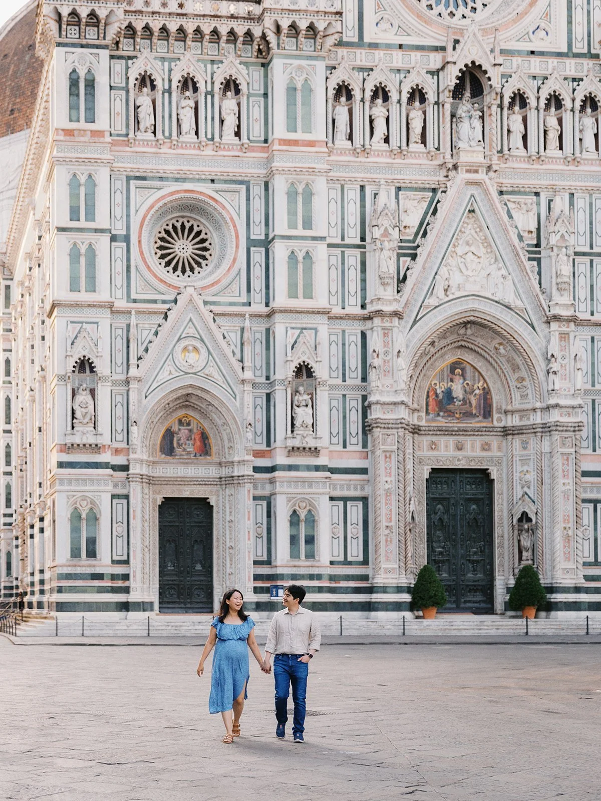 couple hand-in-hand by duomo in florence, italy