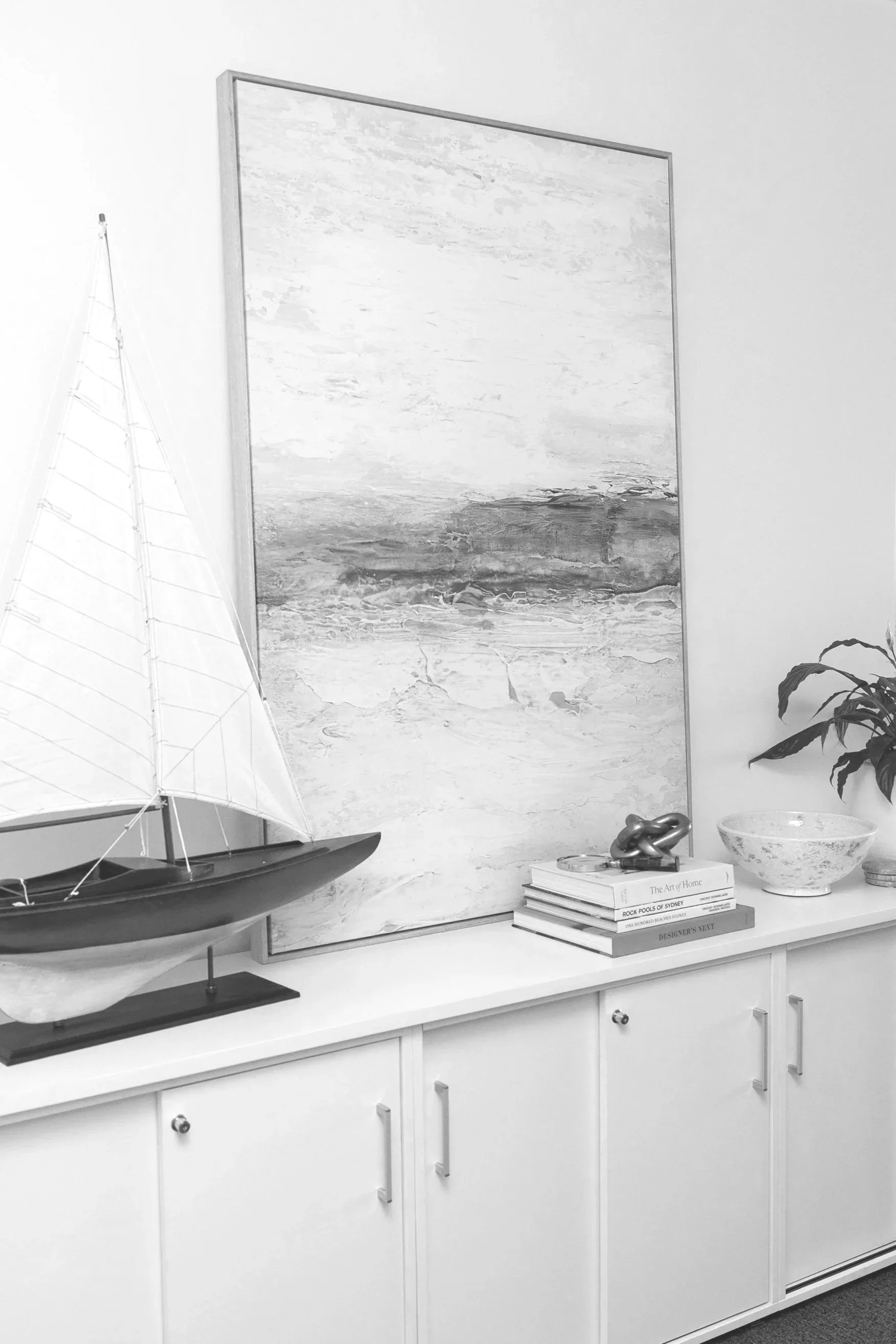 Apex Partners North Sydney offices with decorative sideboard with model sailboat, abstract artwork, books, and a plant.