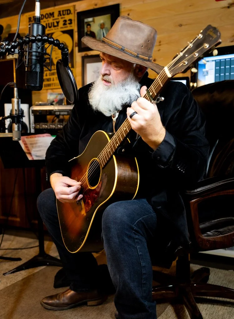 Bearded man playing guitar in studio