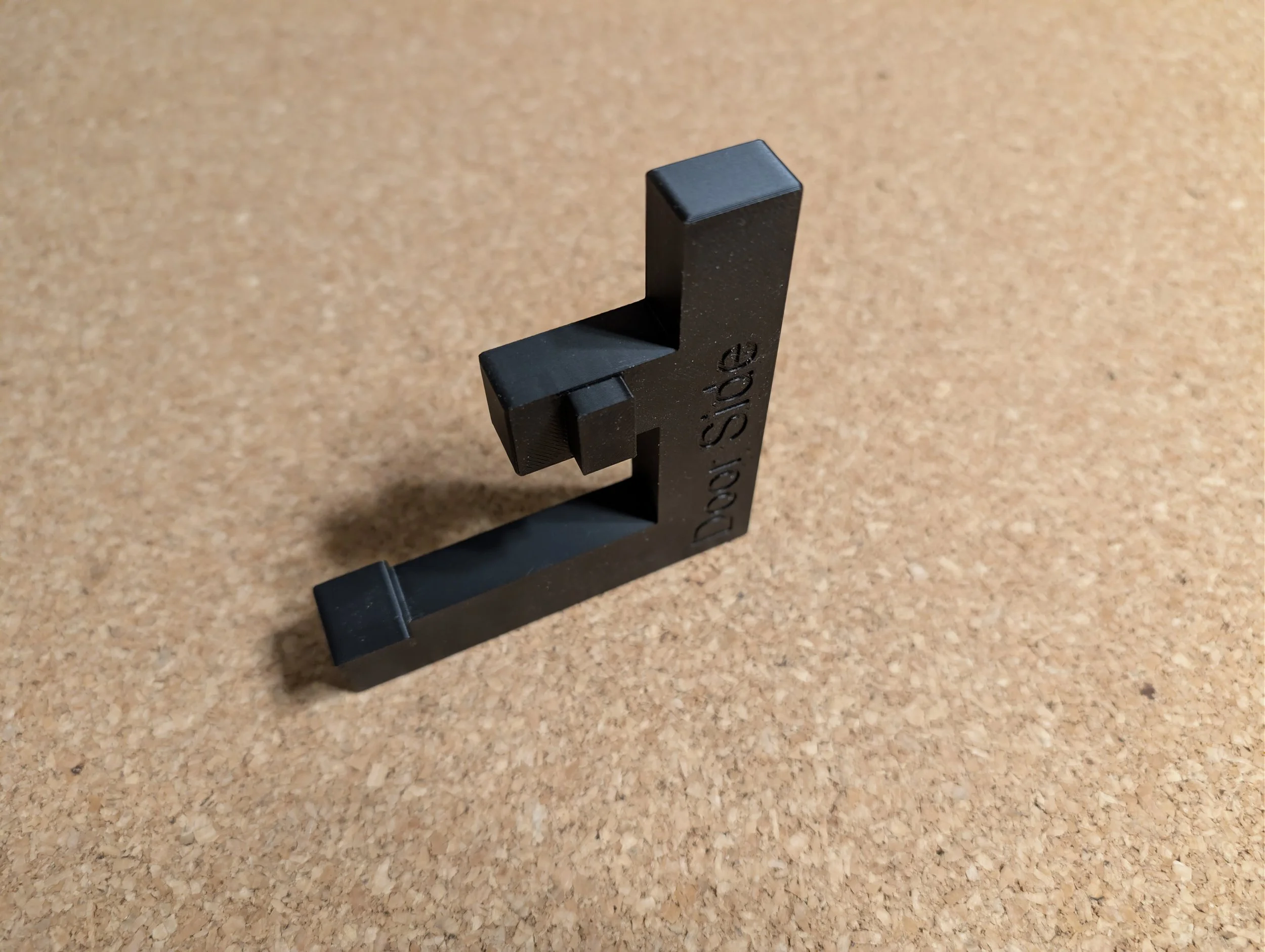 a black plastic product, very similar in shape to a capital letter "F" .