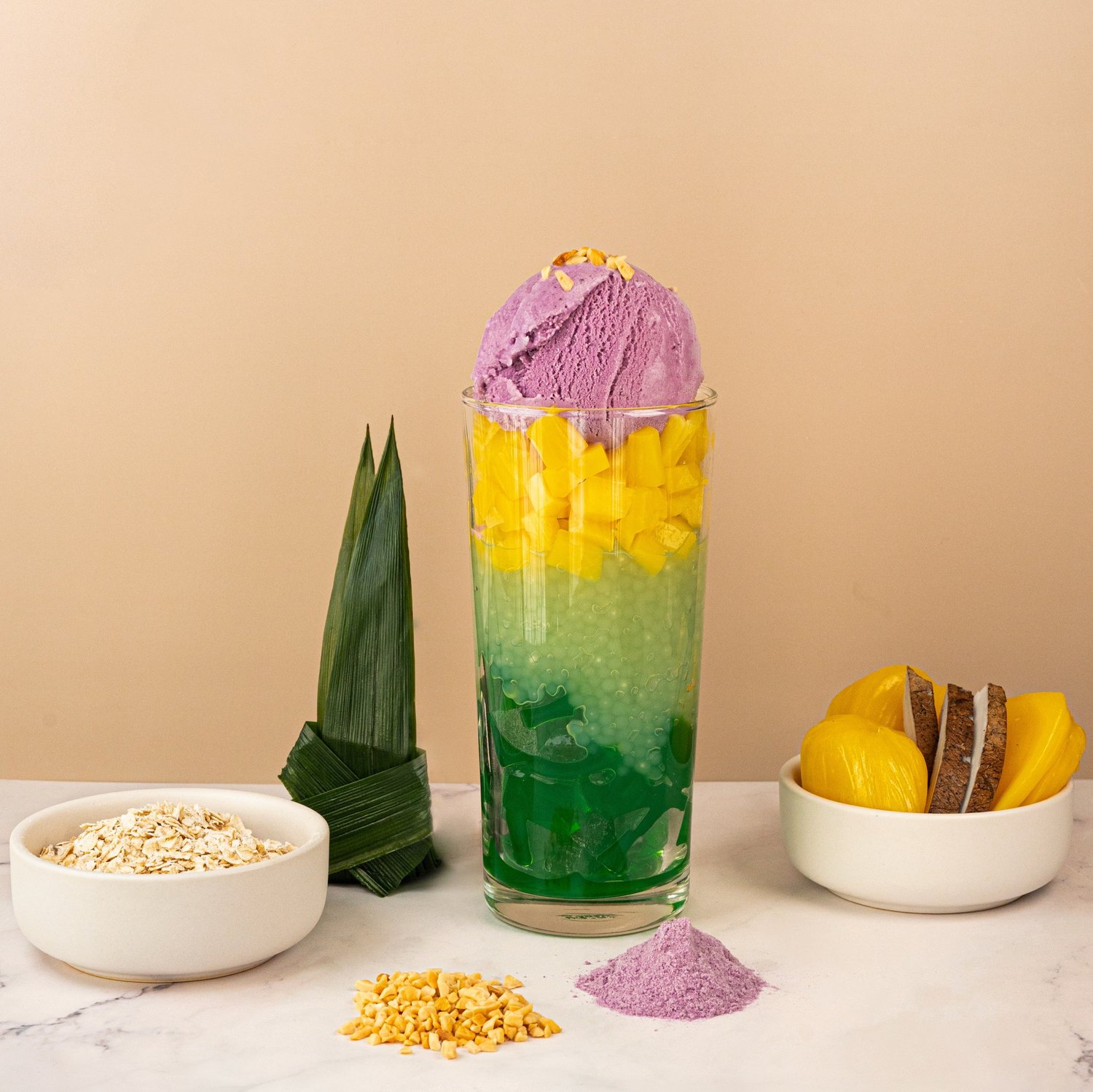 Halo Halo with ube ice cream, coconut jelly and mango in a tall glass