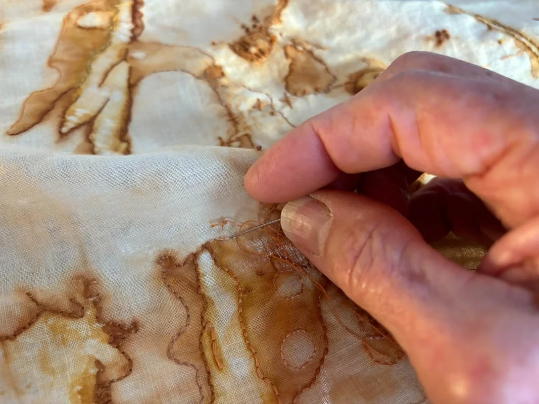Mirka stitching rust-dyed cloth.jpg