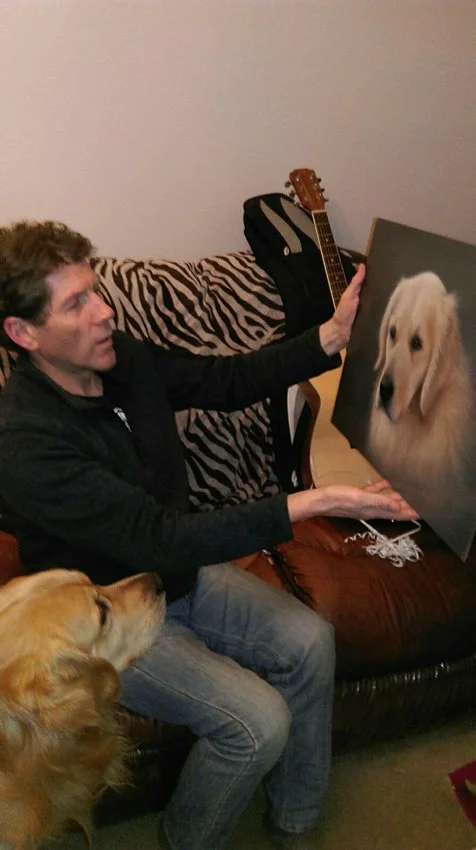 A delighted Ray in Aberdeen, Scotland, with his gifted oil painting, with Charley the Golden Retriever also admiring his self-portrait!