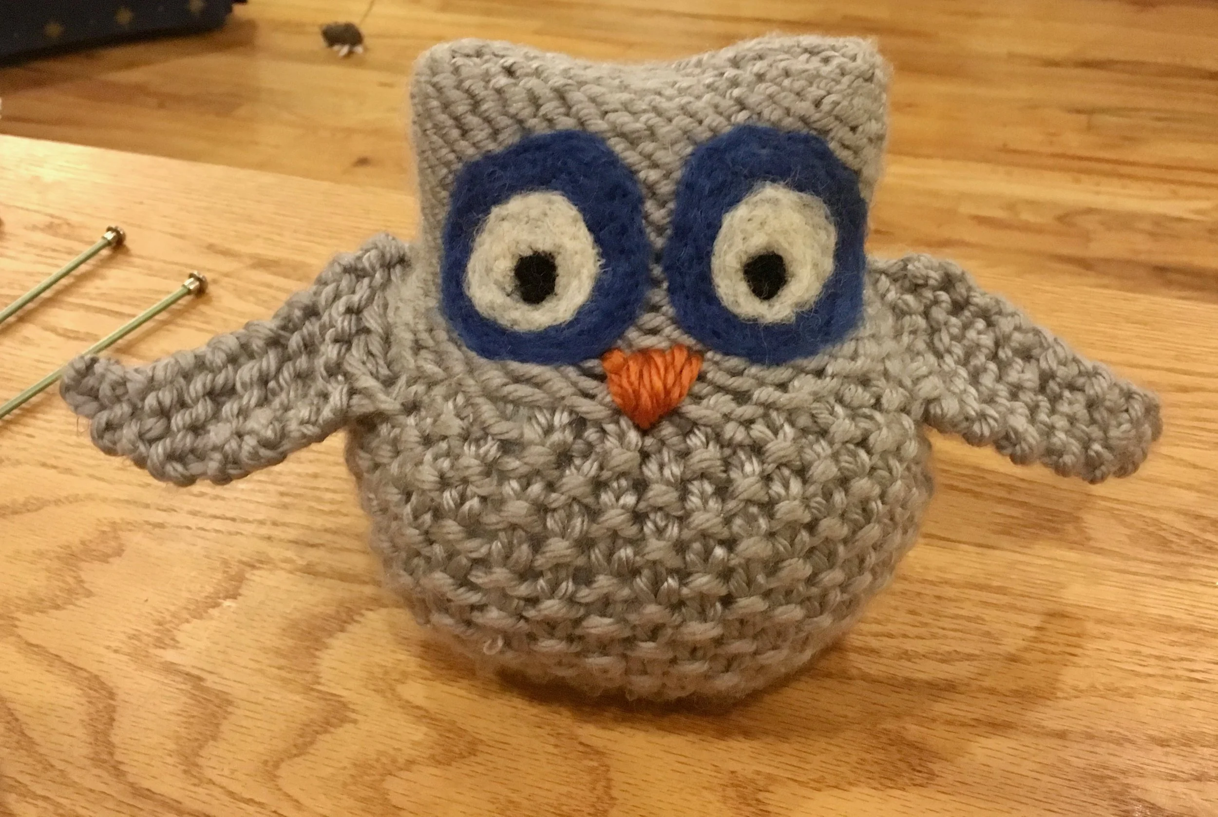 Handmade crocheted owl decor on a wooden table, adding a personal touch to Monica Vasquez’s Portland real estate brand.