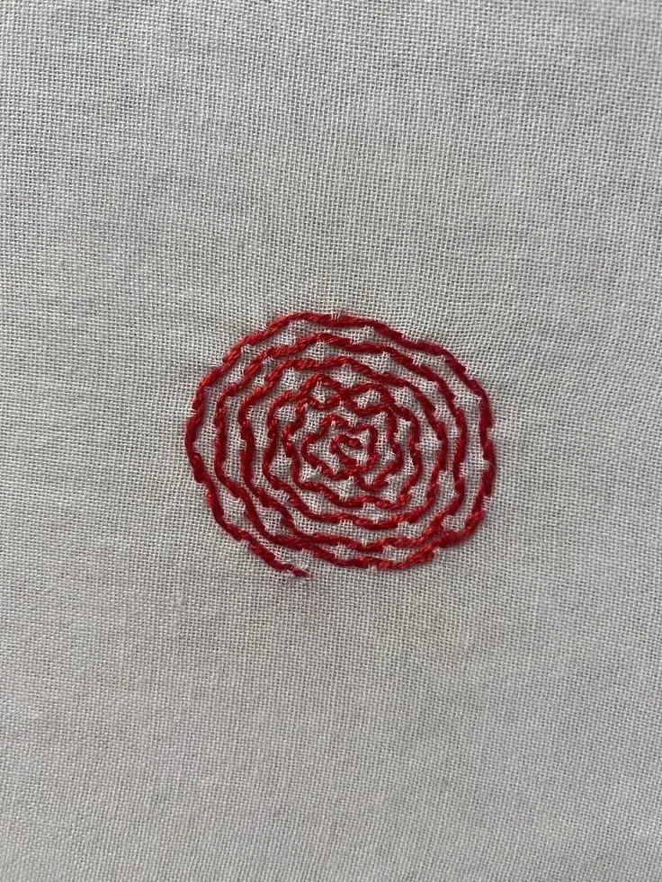 hand embroided spiral in red thread.jpg